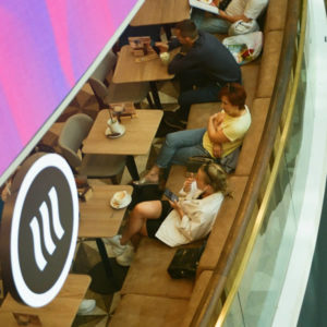 People unaware they're being watched from above at a mall while they eat.