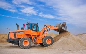 orange bull dozer shoveling sand