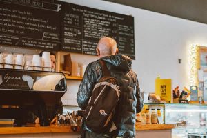 customer standing at a counter, back to camera